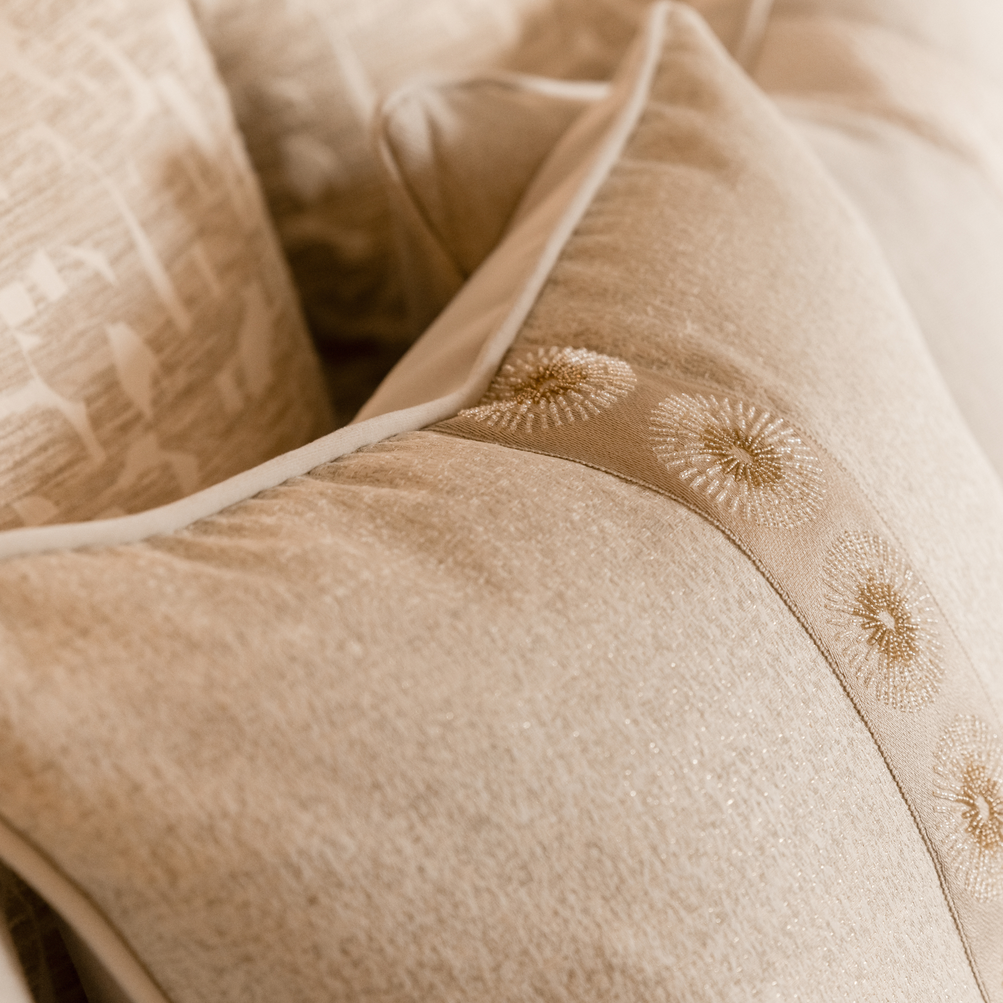 Close-up of beige fabric with intricate solar inspired embroidery