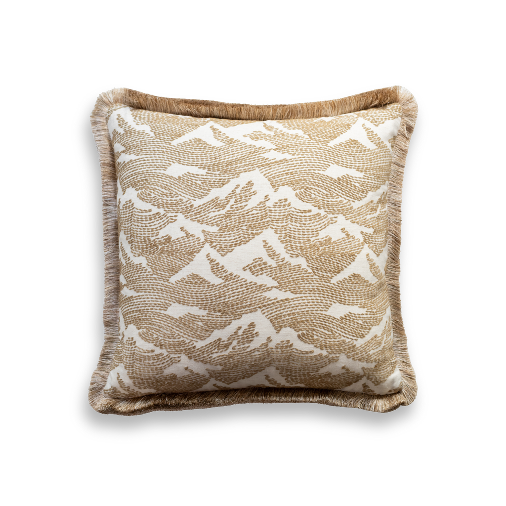 Product shot of the front of a decorative cushion which features a gold and white patterned fabric with an elegant gold fringe around the edge of the cushion.