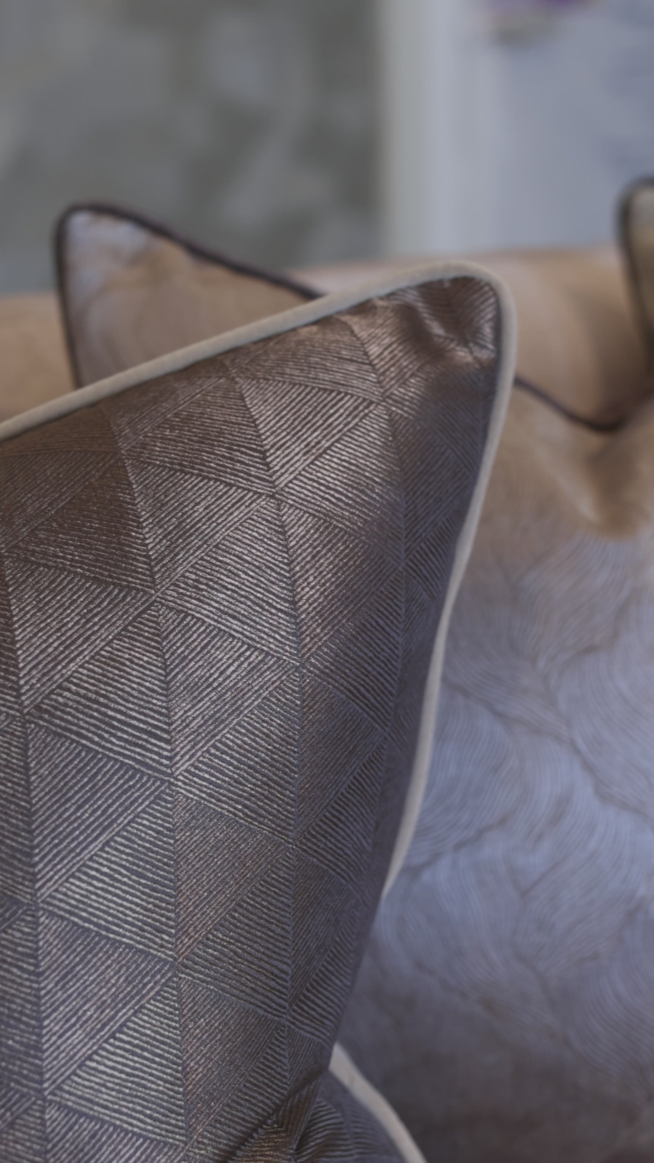 Close-up video of a cushion with intricate abstract patterns etched onto the fabric in bronze metallic tones.