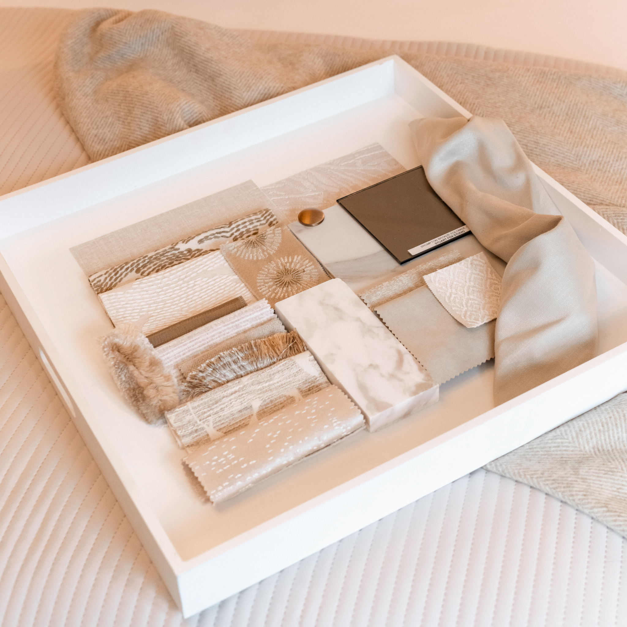 Set of fabric swatches in a white box on a beige fabric background